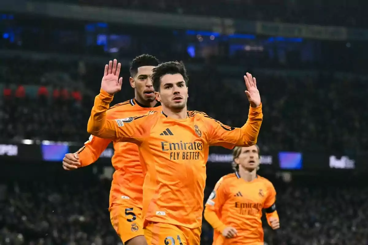 Jugadores de fútbol con uniforme naranja celebran en el campo durante un partido. Jugadores de fútbol con uniforme naranja celebran en el campo durante un partido.